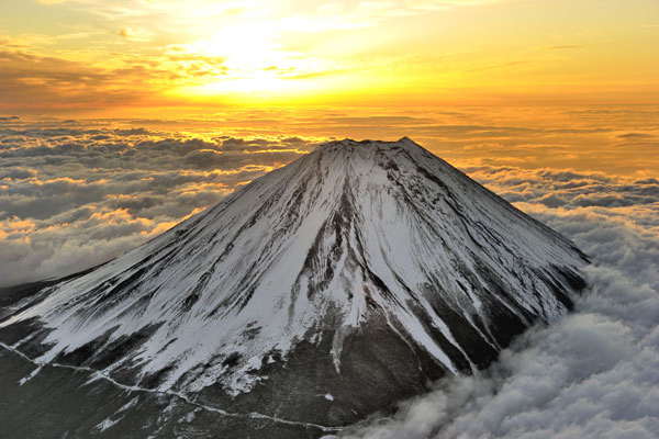 朝日に染まる雲海に立つ富士山