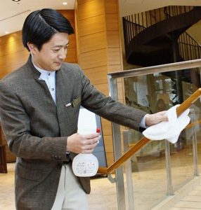 手すりをアルコール消毒するスタッフ＝富士吉田市のハイランドリゾートホテル＆スパ