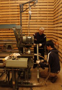 企画展で展示する織り機を準備する渡辺徳重さん（奥）ら＝富士吉田市富士見１丁目