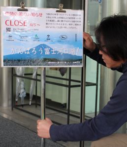 臨時休館を知らせる案内を設置する富士河口湖ふるさと振興財団のスタッフ＝富士河口湖町河口