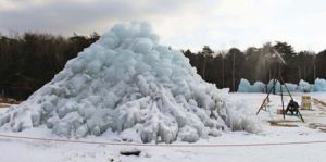 スプリンクラーで水をまいて制作した氷の富士山＝富士河口湖町西湖