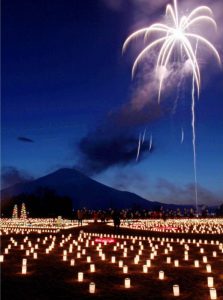 約６千個のろうそくが並ぶ中、花火が上がる会場＝山中湖村平野