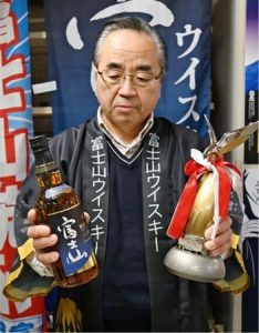 大賞を受賞した富士山ウイスキーとトロフィーを紹介する深沢央社長＝富士吉田市内