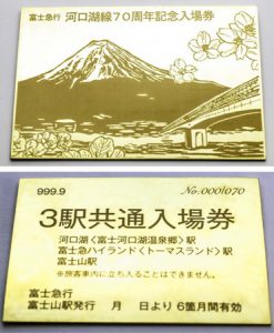 河口湖線開業７０周年を記念して発売した純金製の入場券「３駅共通券」の表面（写真上）と裏面