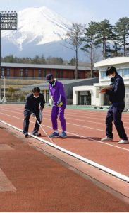 富士北麓公園陸上競技場について、第２種競技場としての規格を満たすかどうか検定する日本陸連の担当者ら＝富士吉田市内（３月２７日）