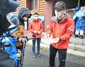 安全登山に関するパンフレットを手渡して登山上の注意を呼び掛ける署員（右）＝富士山５合目