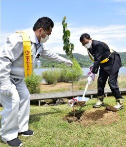 オオヤマザクラの苗木を植える野口英一理事長（右）と権正雅彦山中湖村観光課長＝山中湖交流プラザきらら