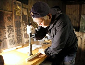 焼き印を押す羽田徳永さん＝富士山１合目馬返し付近