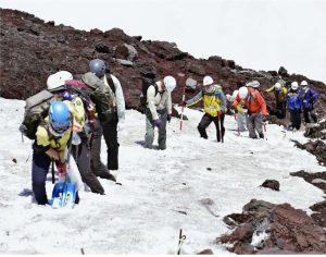 雪が残る登山道を調査する関係者＝富士山