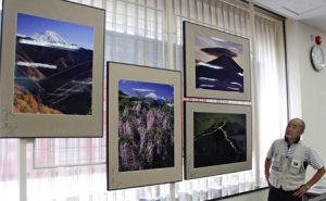 展示された写真と宮下清正さん＝富士吉田・山梨中央銀行明見支店