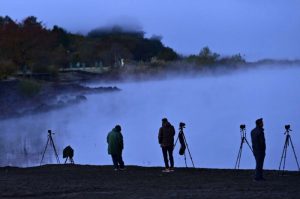 今季初の冬日となった山中湖。湖畔にはカメラマンの姿も見られた＝山中湖村平野