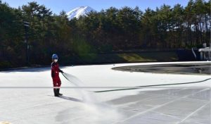 スケートリンクに水をまくスタッフ＝富士吉田市内