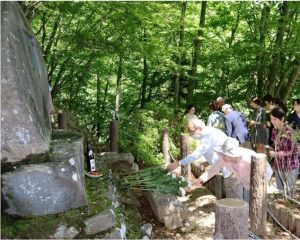 文学碑に花を手向けて太宰治をしのぶ参加者＝富士河口湖町の御坂峠